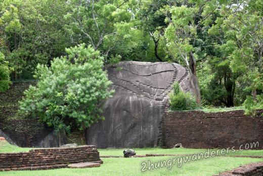 A whole building was perched on this boulder at some point. Now only the holes that supported the foundations remain. A whole building was perched on this boulder at some point. Now only the holes that supported the foundations remain.